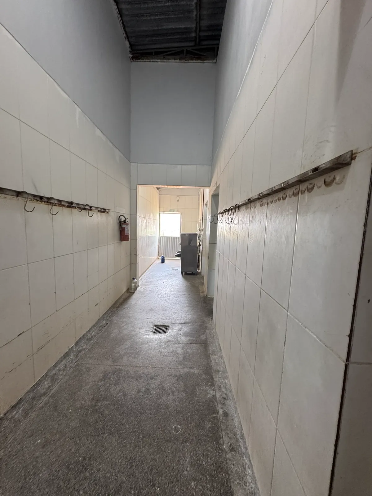 Corredor com ganchos e trilhos de nória para movimentação de carcaças.
