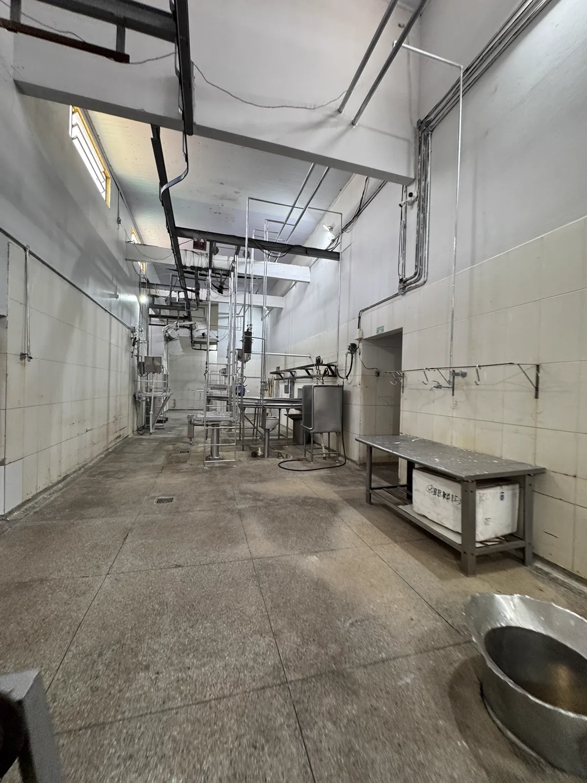Sala de processamento com trilhos aéreos e equipamentos de inox.