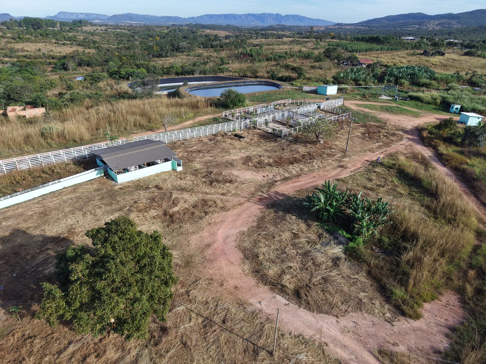 Vista aérea dos currais cercados, com o cinturão de serras ao fundo.